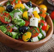 Griekse salade met verse groenten, fetakaas en zwarte olijven foto