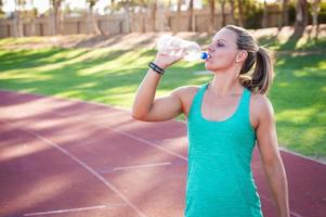 vrouwelijke atleet drinkt uit een fles water foto