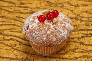 zoete smakelijke muffin met rode aalbessen foto