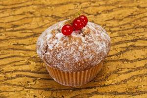 zoete smakelijke muffin met rode aalbessen foto