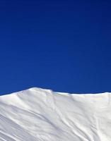 off-piste helling en blauwe heldere hemel in zon winterdag