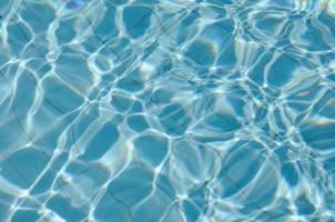 blauw gescheurd water in het zwembad met zonnige reflecties foto