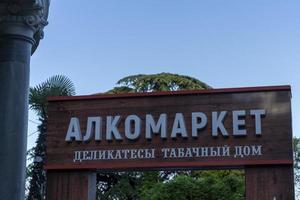 yalta, crimea-12 juni 2021-uithangbord van de alkomarket-winkel tegen de blauwe lucht foto