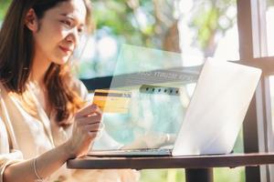 jonge vrouw die creditcardnummer invoert op laptopcomputer die thuis online winkelt met infographics. geselecteerde focus
