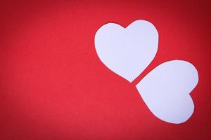 wit hartvormig papier op een rode achtergrond met het concept valentijnsdag foto