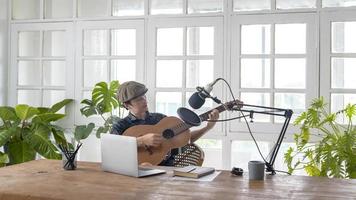 een muzikant schrijft een nummer in de thuisstudio foto