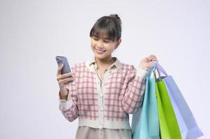 aantrekkelijke shopper vrouw met boodschappentassen op witte achtergrond foto