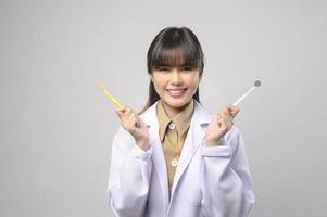 jonge vrouwelijke tandarts glimlachend over witte achtergrond studio foto