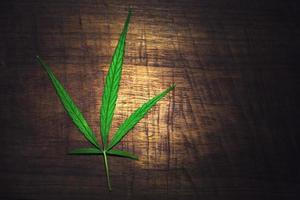cannabisblad op oude houten achtergrond foto