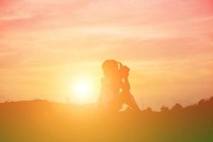 meisje op het strand sms't bij zonsondergang foto