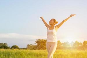 yoga in de stad mooie jonge fitte vrouw die sportkleding draagt, mediteert, ademt, zit met gekruiste benen in halve lotushouding op straat op zomerdag, ardha padmasana, kopieer ruimte foto