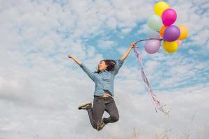 mooi meisje springen met ballonnen op het strand foto