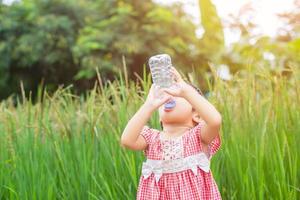 lief klein meisje drinkwater foto