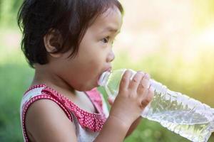 lief klein meisje drinkwater foto