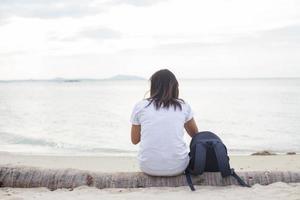 triest eenzame mooie vrouw zittend op de pier foto