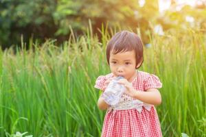 lief klein meisje drinkwater foto