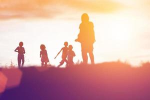 silhouet van een gelukkige kinderen en een gelukkige zonsondergang foto