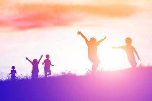 silhouet van een gelukkige kinderen en een gelukkige zonsondergang foto