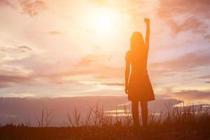 silhouet van een vrouw die bidt over een prachtige hemelachtergrond foto