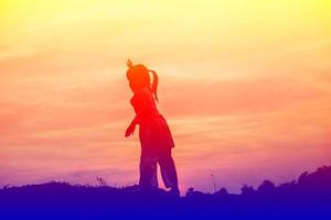 kind silhouet, momenten van vreugde van het kind. op de natuurzonsondergang foto