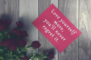 motiverende en inspirerende citaat op rode notitie met rode rozen boeket. foto