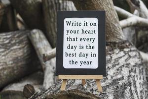 motiverende en inspirerende citaat op een schoolbord geïsoleerd op boomstam. foto