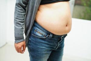 aziatische vrouw toont dikke buik groot formaat overgewicht en obesitas op kantoor. foto