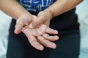 Aziatische senior vrouw pijn haar hand en vinger, de quervain's tenosynovitis. foto