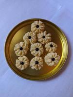 bloemvormige koekjes met choco chips in het midden op gouden bord foto