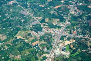 het uitzicht op het groene veld en de boerderij en de stad in het midden van thailand. het schoot vanuit jetplane. foto