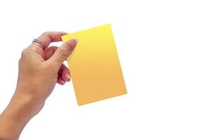 vrouwenhand die de gele kaart op witte duidelijke achtergrond houden. foto