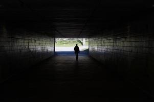 voetganger die door donkere tunnel loopt foto