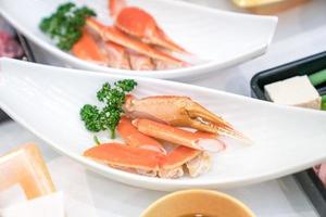 close-up Japanse klauw en been gestoomde krab op witte schotel, versieren met groente ernaast. foto