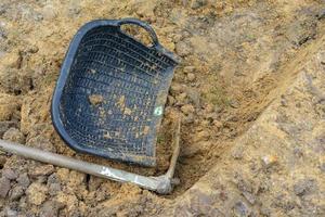 tuinman graaft de grond met zijn uitrusting om te tuinieren en maakt land klaar voor plantage. foto