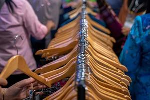 close-up tot hangers aan de bar in een stoffenwinkel met veel mensen die in dat gebied winkelen. foto