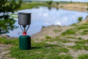 gas toeristenbrander met kookpot en achtergrond rivier foto