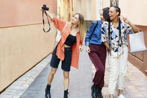 diverse dames met camera genieten van tijd samen op straat foto
