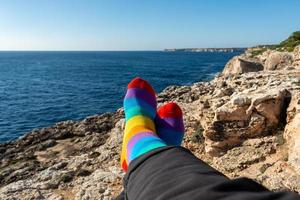 sokken met de kleuren van de vlag van de lgbt-gemeenschap. ontspannen in de voorkant van de zee. trots concept met kopie ruimte foto