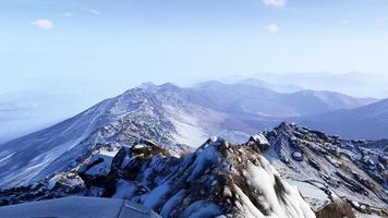 3D-renderinglandschap van met wintersneeuw bedekte bergen en enorme rotsen, heldere luchten. foto