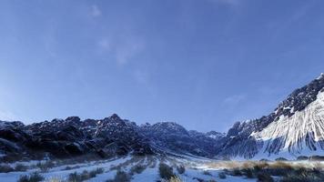 3D-renderinglandschap van met wintersneeuw bedekte bergen en enorme rotsen, heldere luchten. foto