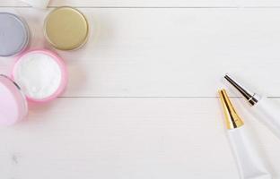 cosmetisch en huidverzorgingsproduct op witte houten tafel, schoonheid met behandelingscrème en vochtinbrengende crème op houten bureau, gezondheids- en wellnessconcept, bovenaanzicht. foto