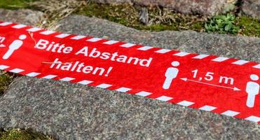 houd afstandssymbool in de Duitse taal 2 meter sociaal afstandsbord voor covid 19. foto