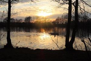 prachtig zonsonderganglandschap aan een meer met een reflecterend wateroppervlak foto
