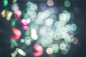 achtergrondvervaging van kerstbomen met ornamenten, geschenkdozen en groene toon bokeh. foto