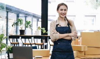 portret van aziatische jonge vrouw mkb werkend met een doos thuis de werkplek. start-up kleine ondernemer, kleine ondernemer mkb of freelance bedrijf online en leveringsconcept. foto