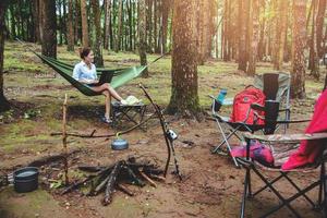 Aziatische vrouwen reizen natuurlijk ontspannen. zittend werken met behulp van een notebook. in de hangmat. camping in het nationale park doi inthanon in chiangmai. in Thailand foto