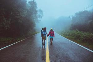 minnaar aziatische man en aziatische vrouwen reizen de natuur. lopen op de weg route. de natuur gelukkig reizen. te midden van de mist regenachtig. foto