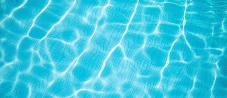 oppervlakte van blauw zwembad, achtergrond van water in zwembad. zomerplezier, recreatieve buitenactiviteit, zonnig blauw wateroppervlak foto