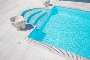 luxe zwembad in Santorini, zonnige witte marmeren decoratie, rustige close-up vakantie en reissjabloon foto