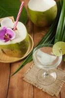 kokosschil en vers kokossap in een glas champagne op een houten tafel foto